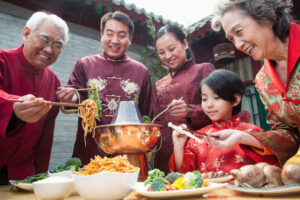 Family enjoying Chinese meal in traditional Chinese clothing